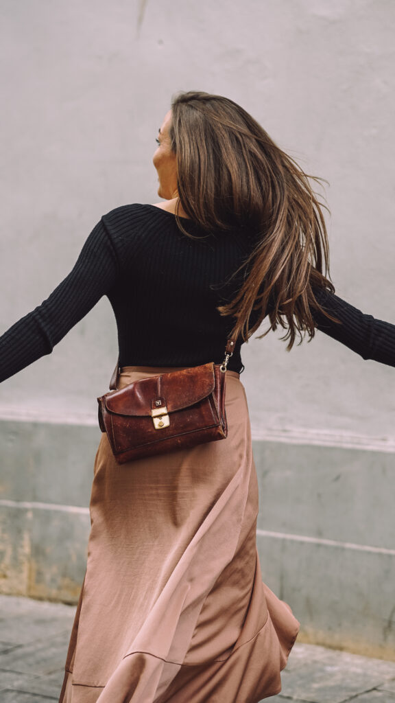 Authentisches Foto von drehender Frau mit langen braunen Haaren in Bewegung