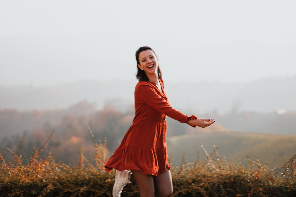 Authentisches Fotoshooting in Südsteiermark mit Frau im orangen Graz in der Herbstlandschaft bei Sonnenuntergang