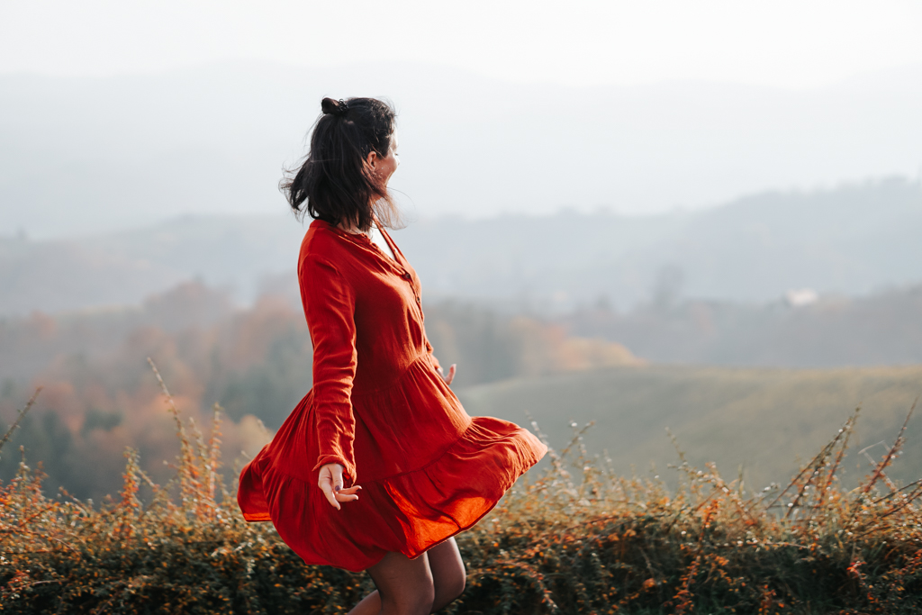Frau im orangen Kleid in Herbstlandschaft in Südsteiermark
